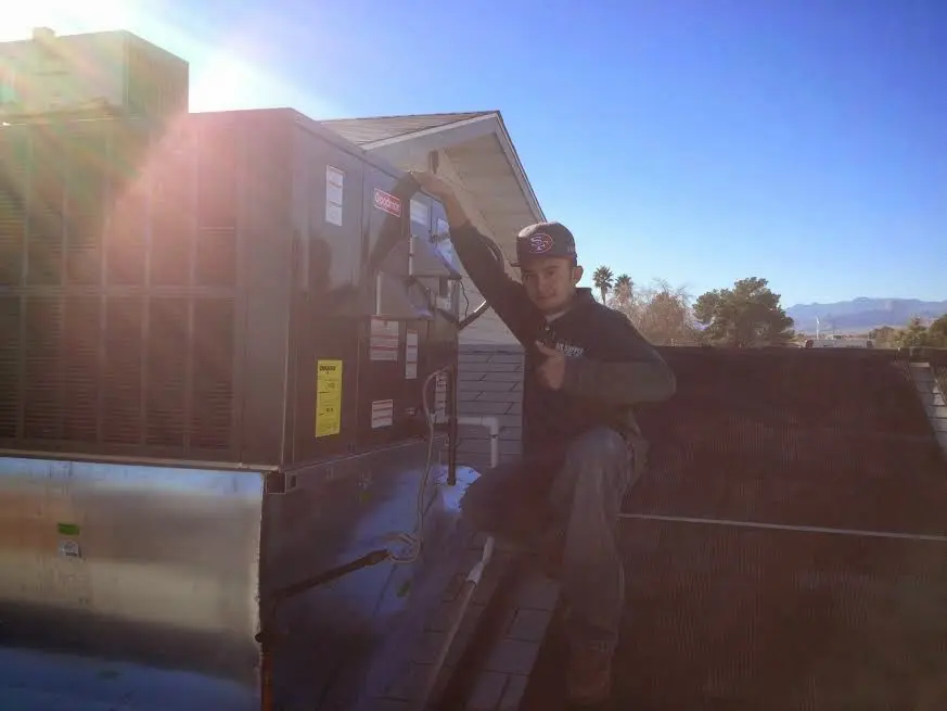 HVAC technician performing AC Tune-Up on a rooftop unit in Kirkwood